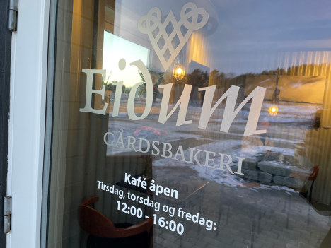 Nærbilde av tekst på dør, viser åpningstider