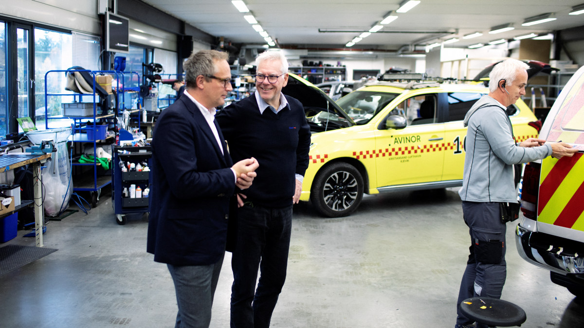 Trond og Morten snakker sammen på verksted med uttrykningsbil fra Avinor i bakgrunnen.